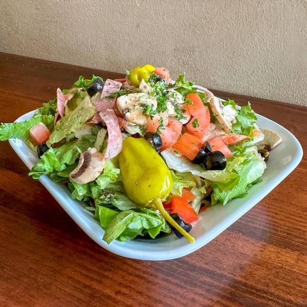 Petrini's Italian salad with lettuce, salami, mushrooms, tomatoes, olives, and a pepperoncini.
