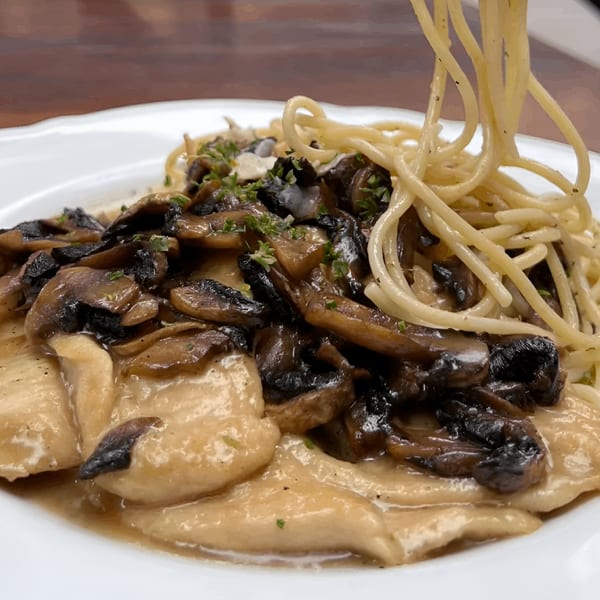 Petrini's chicken marsala with mushrooms and spaghetti being twirled on a fork.